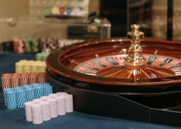 Roulette wheel with casino chips stacked on roulette table.
